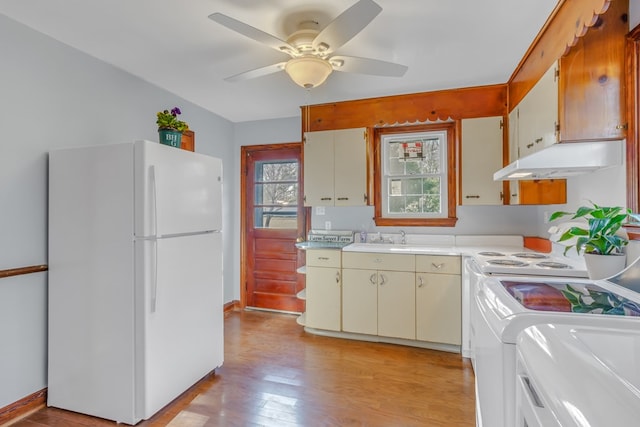 kitchen featuring under cabinet range hood, freestanding refrigerator, light wood-style floors, light countertops, and ceiling fan