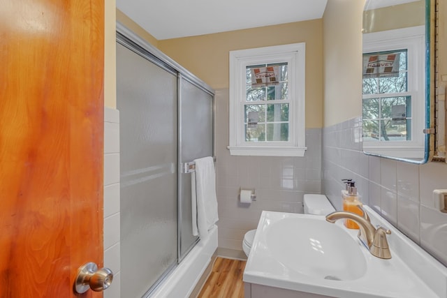 full bathroom with a shower stall, toilet, tile walls, and wood finished floors