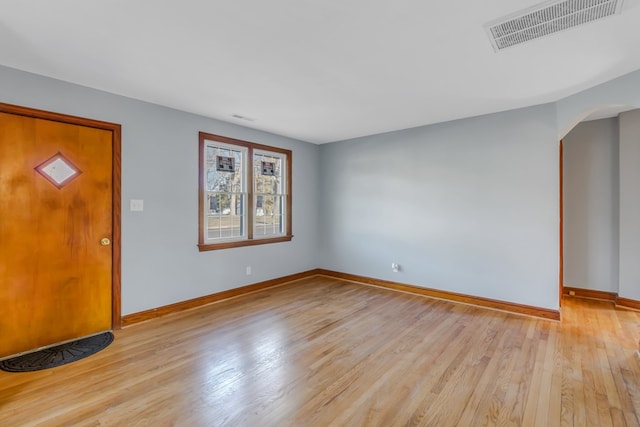 entryway featuring arched walkways, visible vents, light wood finished floors, and baseboards
