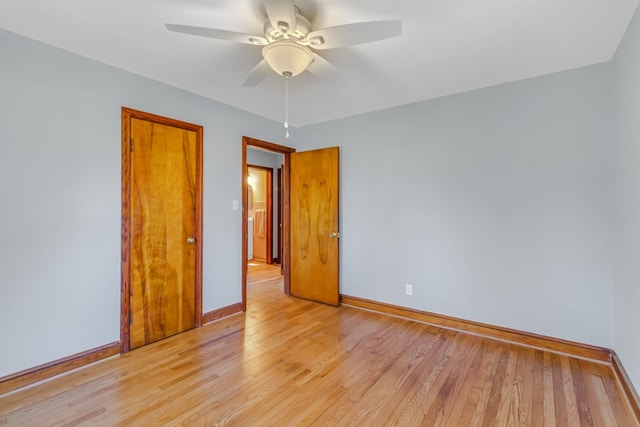 unfurnished room featuring light wood finished floors, baseboards, and a ceiling fan