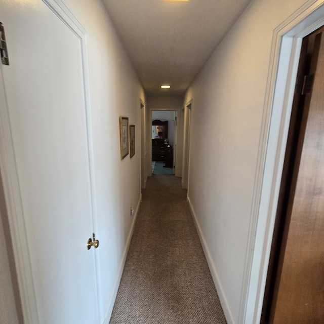 hallway featuring baseboards, carpet flooring, and recessed lighting