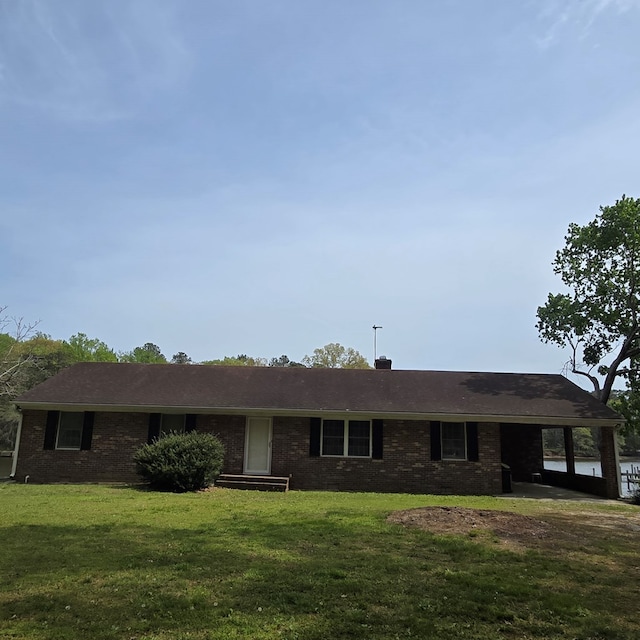 ranch-style house featuring brick siding and a front yard