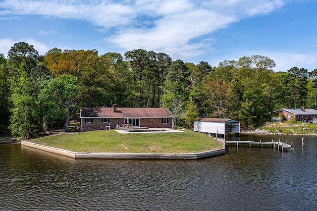 back of property featuring a lawn, a forest view, and a water view