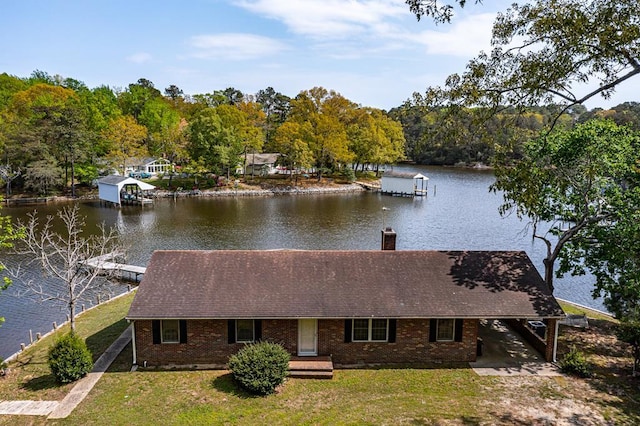 view of dock with a lawn and a water view