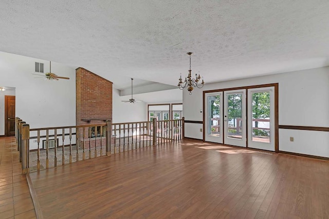 1061 Twiggs Ferry Rd, Hartfield, VA 23071 - empty room with a textured ceiling, a ceiling fan, a chandelier, wood finished floors, and lofted ceiling