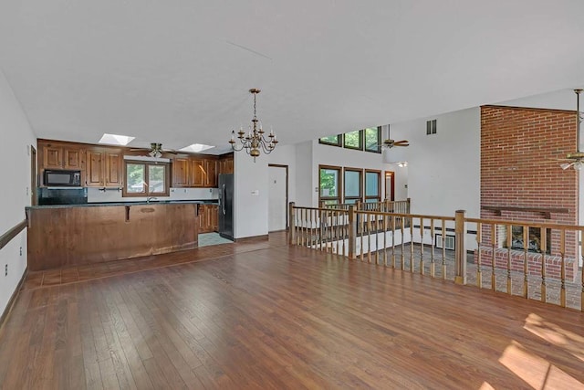 1061 Twiggs Ferry Rd, Hartfield, VA 23071 - kitchen with black appliances, dark wood-style floors, a peninsula, brown cabinets, and dark countertops
