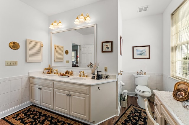 326 Coppedge Farm Rd, White Stone, VA 22578 - full bathroom with tile walls, wood finished floors, toilet, double vanity, and a wainscoted wall