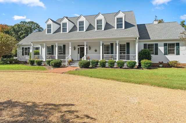 cape cod house featuring covered porch, roof with shingles, and a front yard