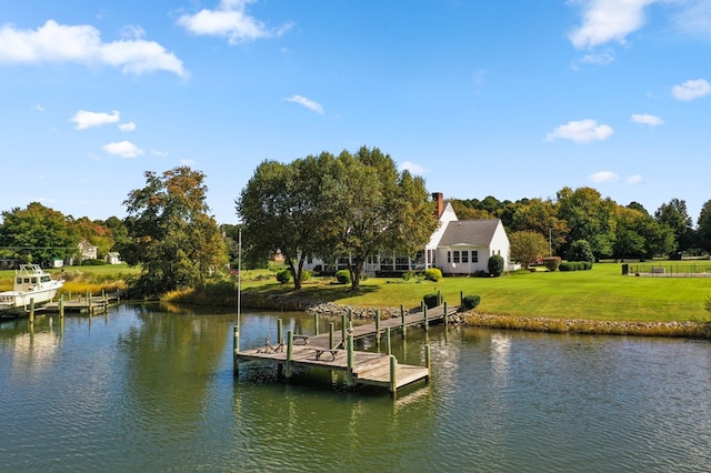 view of dock featuring a water view and a yard