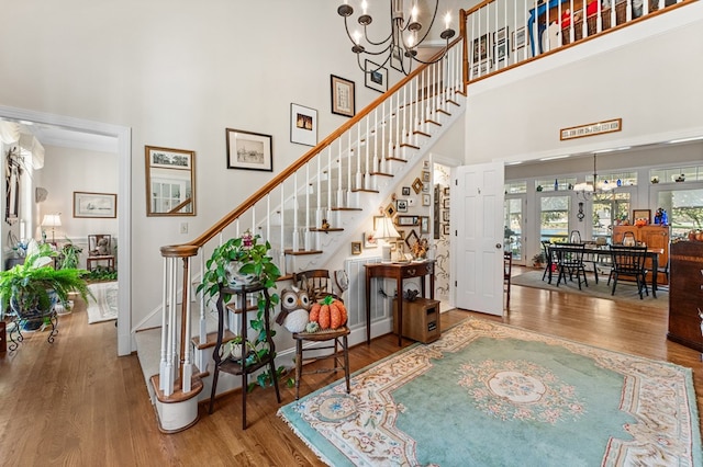 foyer featuring a chandelier, wood finished floors, and a towering ceiling