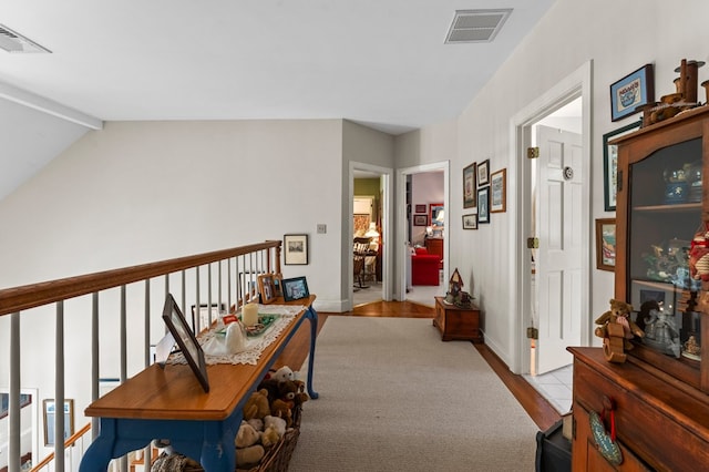 corridor with baseboards, visible vents, wood finished floors, and beamed ceiling