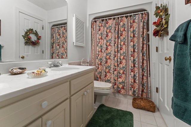 bathroom with toilet, vanity, and tile patterned floors