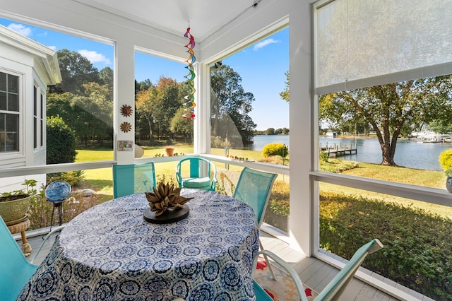 sunroom featuring a water view