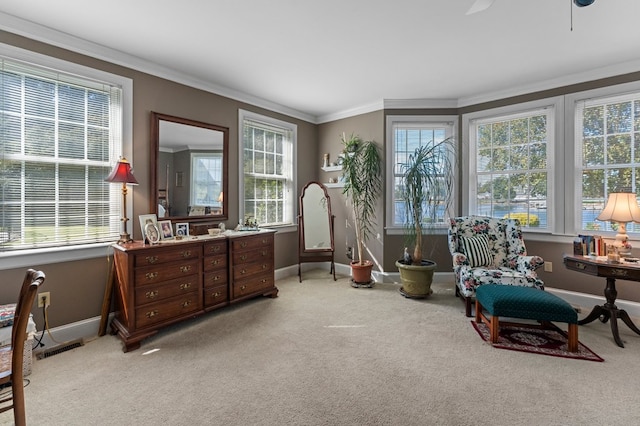 living area featuring baseboards, ornamental molding, visible vents, and light colored carpet