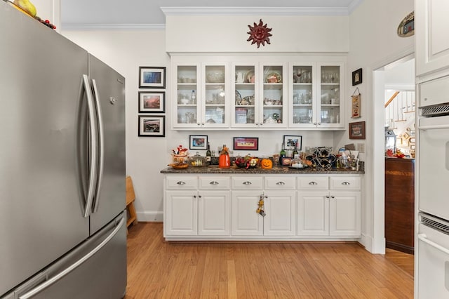 kitchen with ornamental molding, freestanding refrigerator, and light wood finished floors