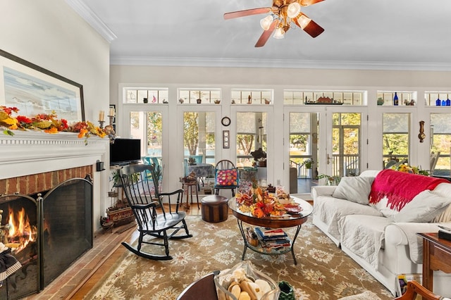 living room with wood finished floors, a ceiling fan, french doors, ornamental molding, and a brick fireplace