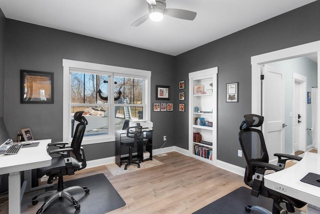 office area with a ceiling fan, baseboards, and light wood-style flooring