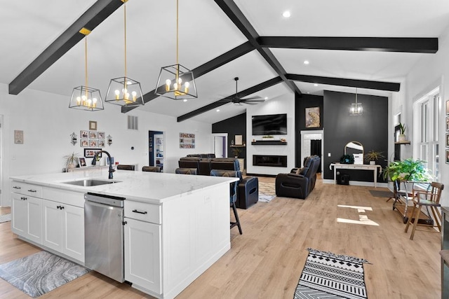 kitchen featuring white cabinetry, sink, hanging light fixtures, a kitchen island with sink, and stainless steel dishwasher