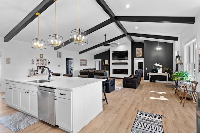 kitchen featuring a sink, stainless steel dishwasher, white cabinets, a chandelier, and light wood-style flooring
