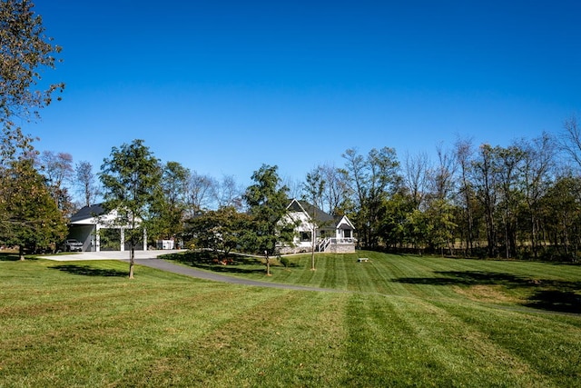 view of property's community with driveway and a lawn