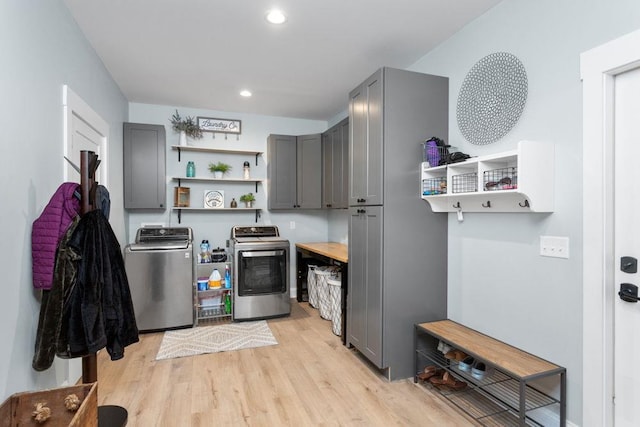 kitchen with gray cabinets, washer and dryer, and light hardwood / wood-style flooring