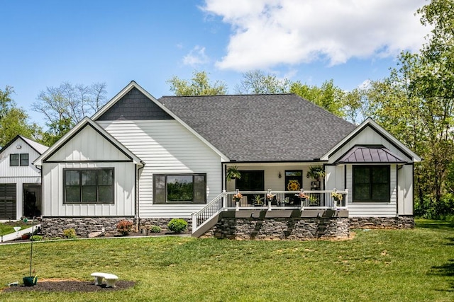 back of property featuring board and batten siding, a yard, a shingled roof, and a porch