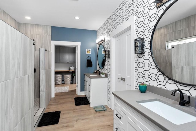 bathroom with vanity, wood-type flooring, and tiled shower