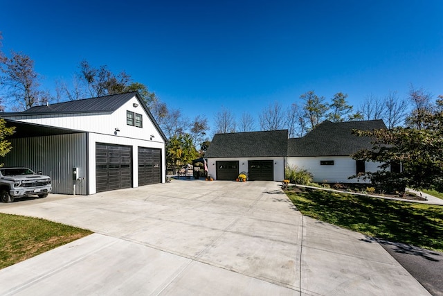 view of home's exterior with a detached garage, an outbuilding, and concrete driveway
