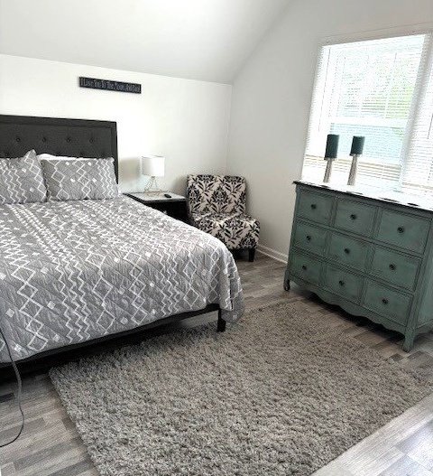 bedroom featuring lofted ceiling and light hardwood / wood-style flooring