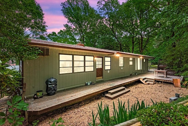 back house at dusk with a deck