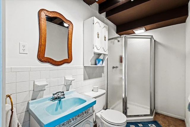 bathroom featuring vanity, tile walls, tile patterned flooring, toilet, and a shower with shower door