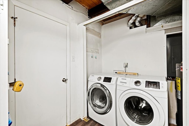 washroom featuring electric panel, water heater, dark hardwood / wood-style floors, and independent washer and dryer