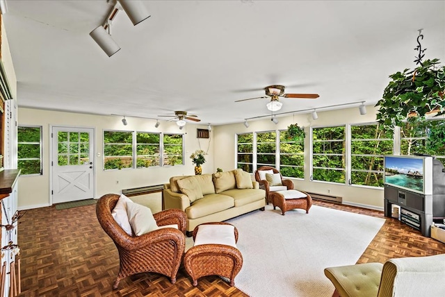 sunroom / solarium featuring baseboard heating and ceiling fan