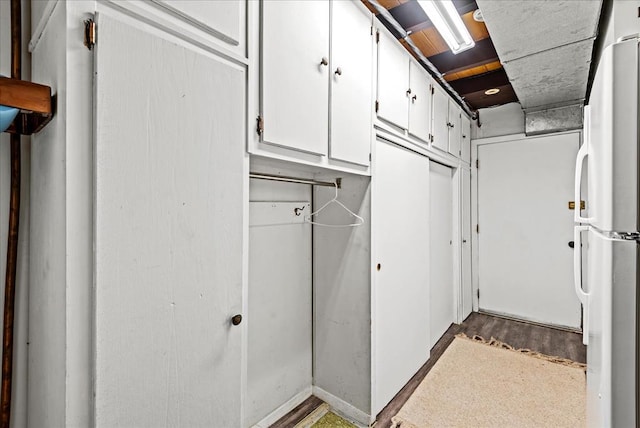 interior space featuring white cabinets and white refrigerator