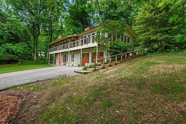 view of front of house with a front lawn, a deck, and a garage