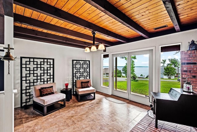 living area featuring a chandelier, a healthy amount of sunlight, beamed ceiling, and wood ceiling