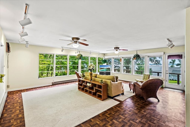 living room with dark parquet flooring, ceiling fan, and a baseboard radiator