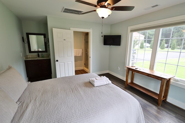 bedroom featuring ensuite bath, ceiling fan, and dark wood-type flooring