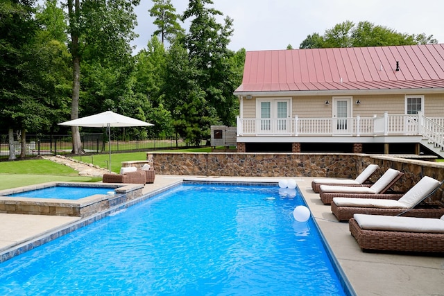 view of swimming pool featuring an in ground hot tub and a wooden deck