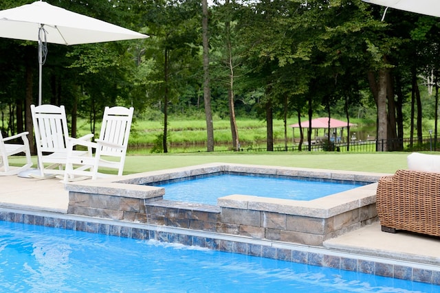 view of pool featuring a yard and a hot tub