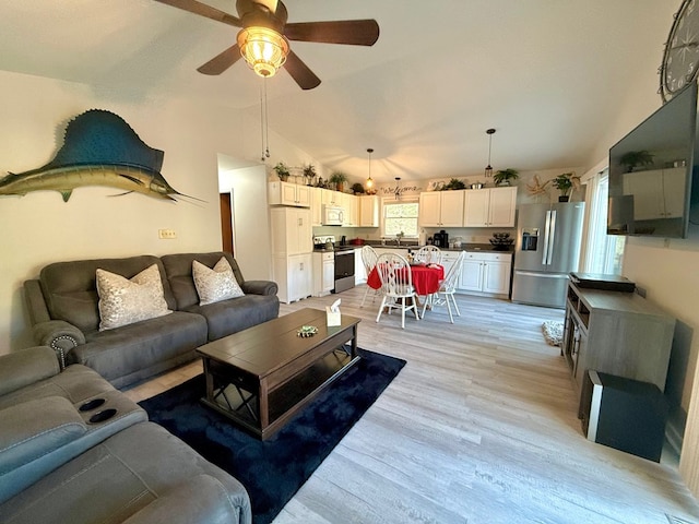 living room with ceiling fan, high vaulted ceiling, and light wood-type flooring