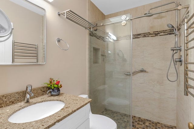 bathroom with vanity, a shower with shower door, and toilet