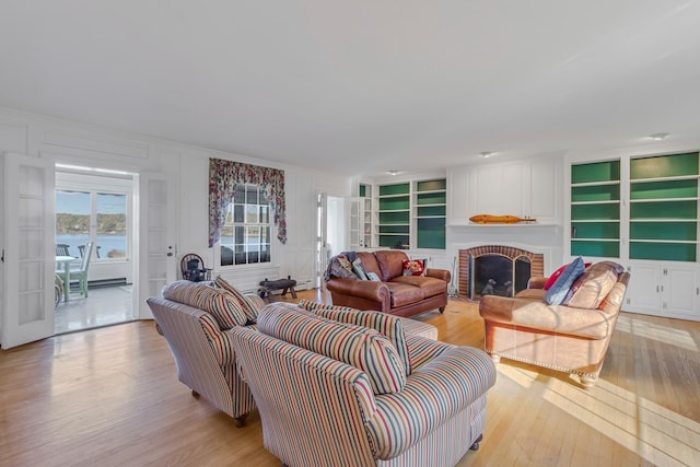 living room with a fireplace and light wood-type flooring