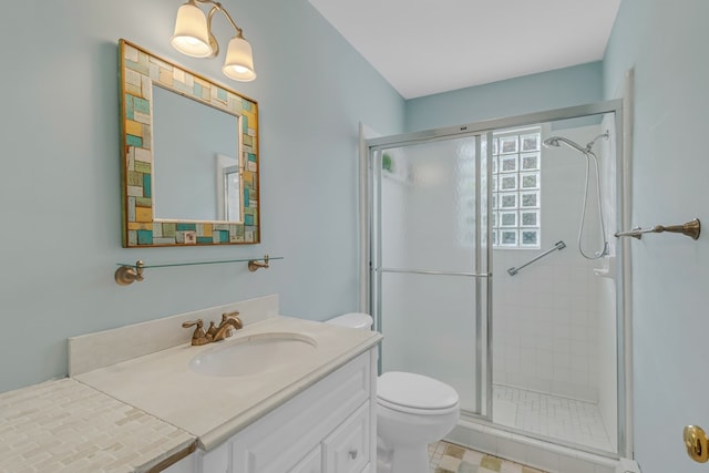 bathroom featuring vanity, an enclosed shower, and toilet