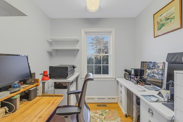 office area with light hardwood / wood-style floors and a baseboard heating unit