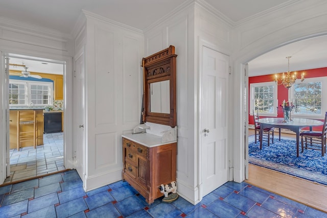 bathroom featuring crown molding and ceiling fan with notable chandelier