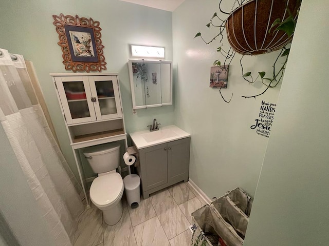 full bathroom with toilet, marble finish floor, baseboards, and vanity