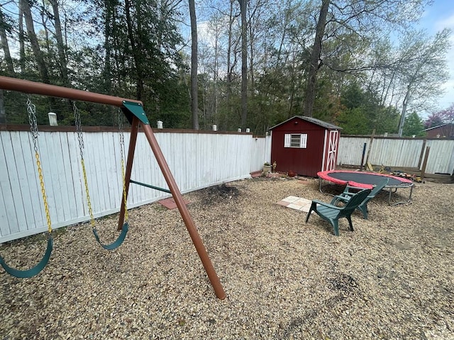 view of jungle gym featuring a storage shed, a fenced backyard, and an outdoor structure