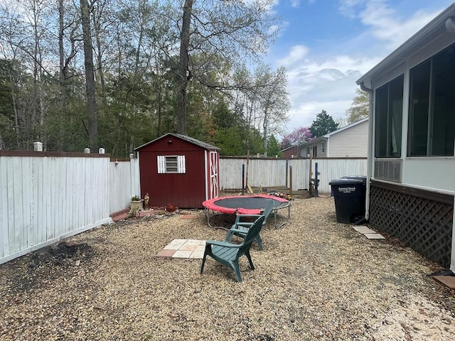 view of yard with a sunroom, a fenced backyard, a shed, and an outdoor structure
