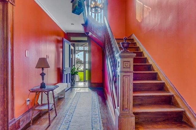 staircase with baseboards, wood finished floors, and crown molding